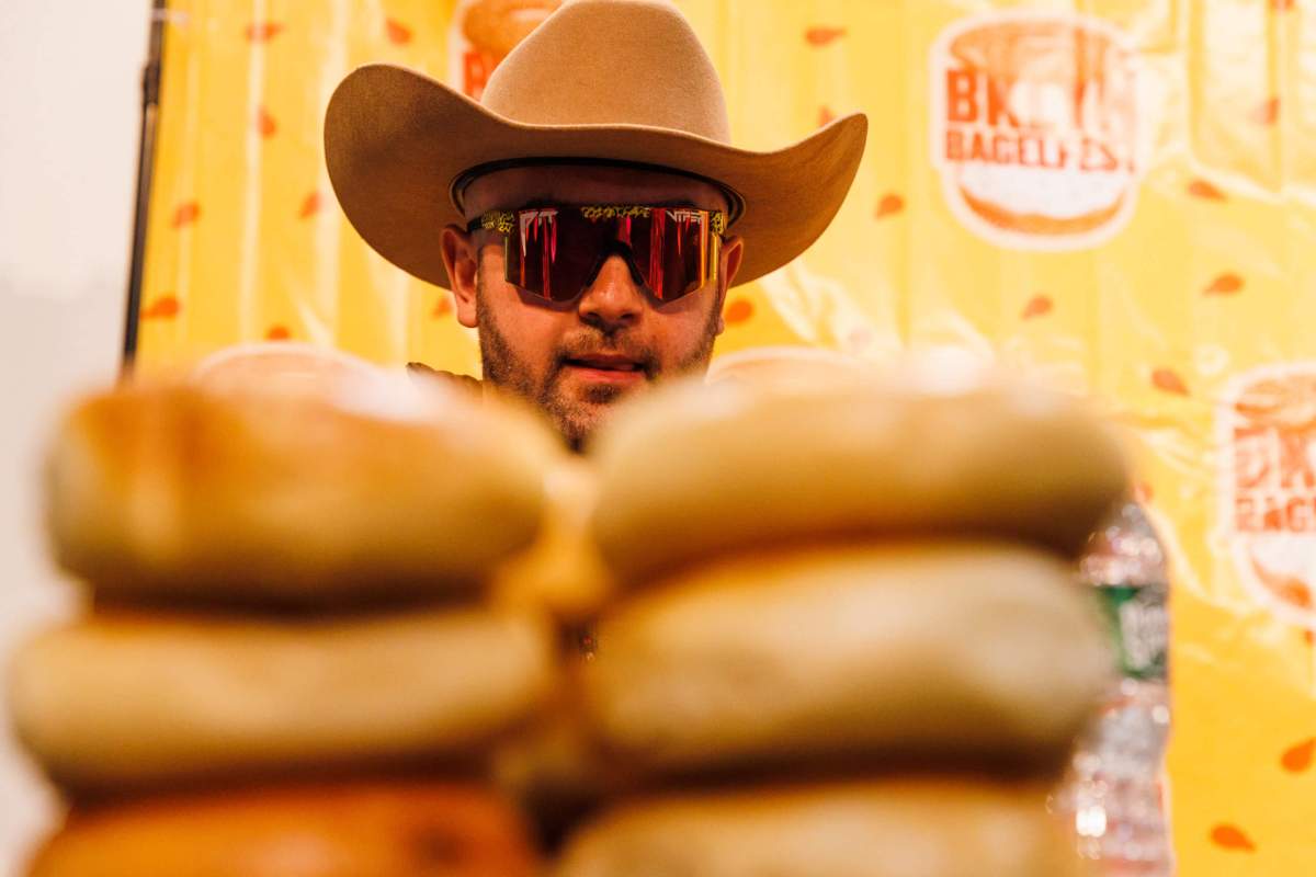 man eyeing stack of bagels at bagelfest winter games 2023