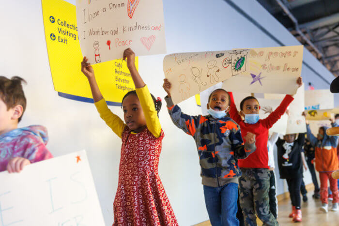 Brooklyn children created posters with inspirational messages and marched around the facility in unity. 