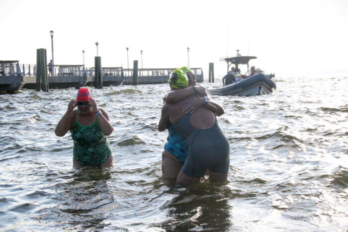 Swimmers hug after completing annual Key Lime Pie swim