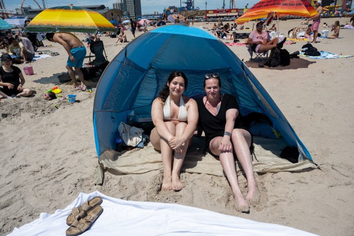 women under beach tent in coney island